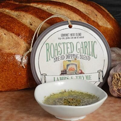 Roasted Garlic bread dipping blend package with loaf of bread, garlic bulb, and oil bowl