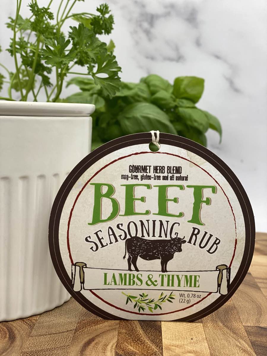 Beef Seasoning Rub package with dip chiller and herbs on wooden cutting board