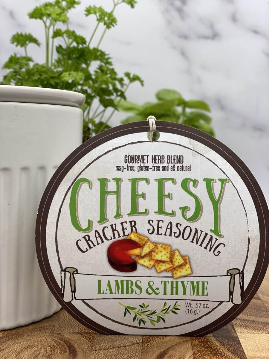 Cheesy Cracker Seasoning package with dip chiller and herbs on wooden cutting board