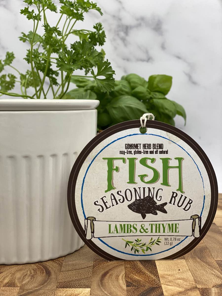 Fish Seasoning Rub package with dip chiller and herbs on wooden cutting board