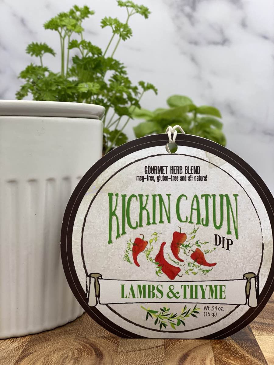 Kickin' Cajun Dip product package displayed with dip chiller on wooden cutting board