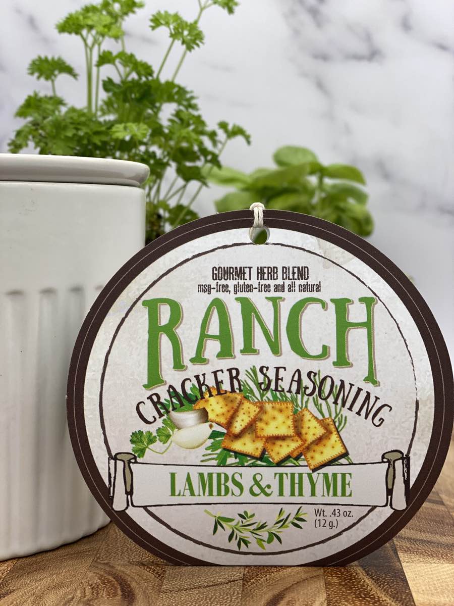 Ranch Cracker Seasoning package with dip chiller and herbs on wooden cutting board