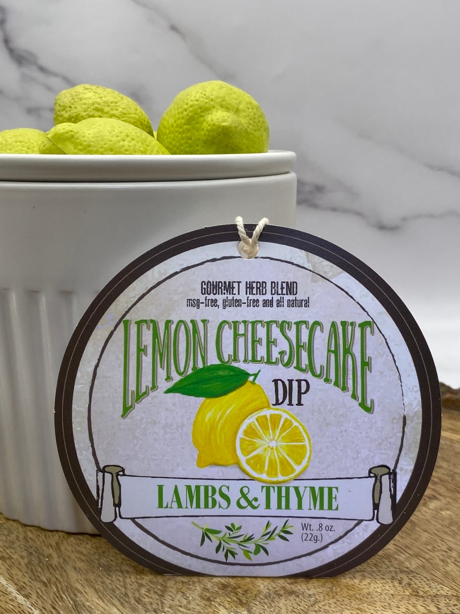 Lemon Cheesecake Dip product package displayed with dip chiller on wooden cutting board